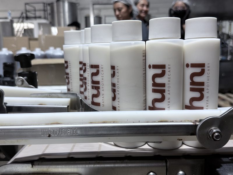 huni conditioner bottles on factory conveyor belt